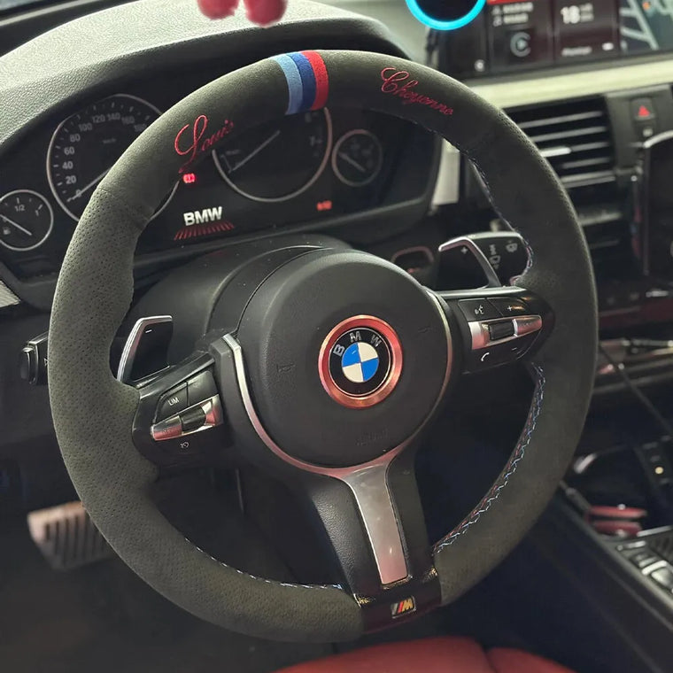 BMW steering wheel with dark Alcantara, red script embroidery and a blue-red center marker
