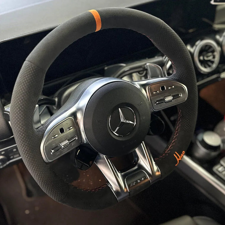 Mercedes-Benz steering wheel with dark Alcantara, orange script embroidery and an orange center marker