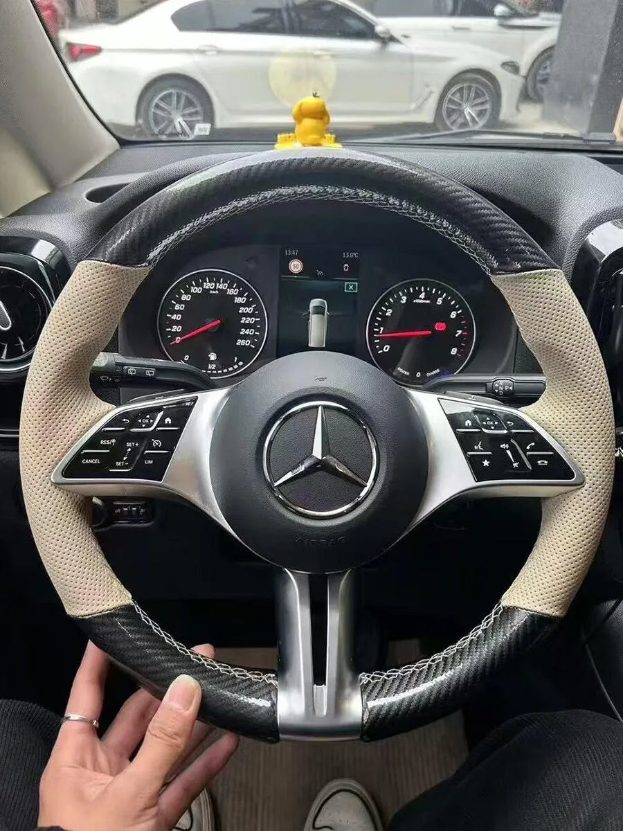 Mercedes-Benz custom steering wheel cover with carbon-fiber-style sections and beige perforated grips